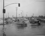 Automobiles driving through flooded intersection in L.A. - 1950